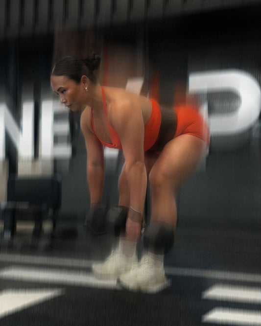 woman doing deadlift variations with uppper lifting straps