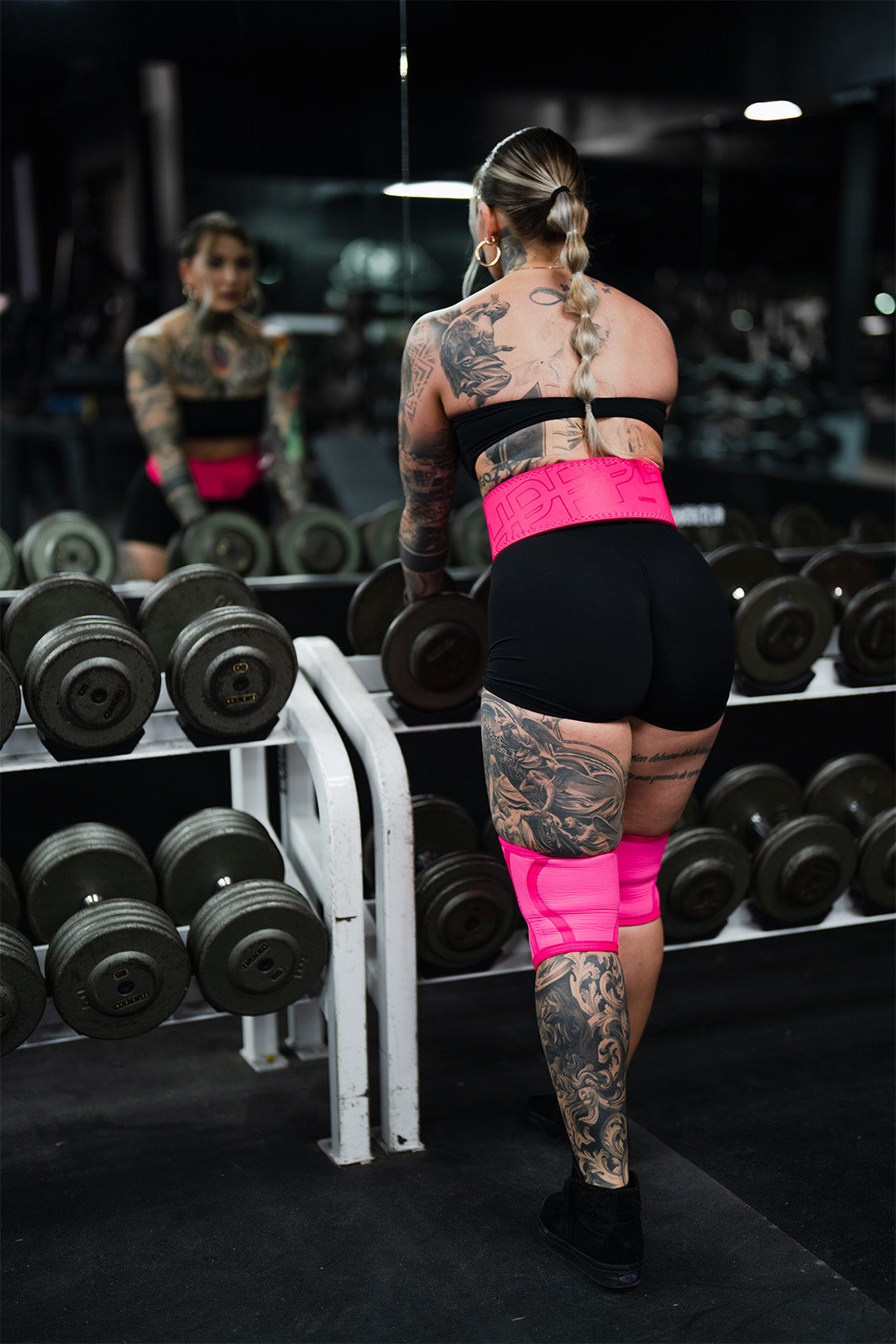 woman grabbing dumbbells at the gym