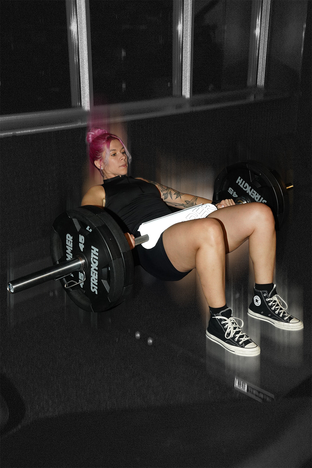 woman doing barbell hip thrust with uppper barbell pad